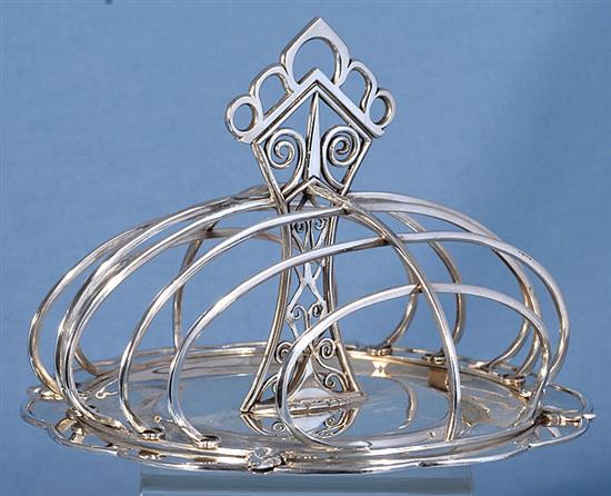 A good George V Arts & Crafts silver seven bar toast rack, Diameter :7 ¼”/183mm Height 5 ¼”/135mm Weight: 17.2oz/487grms